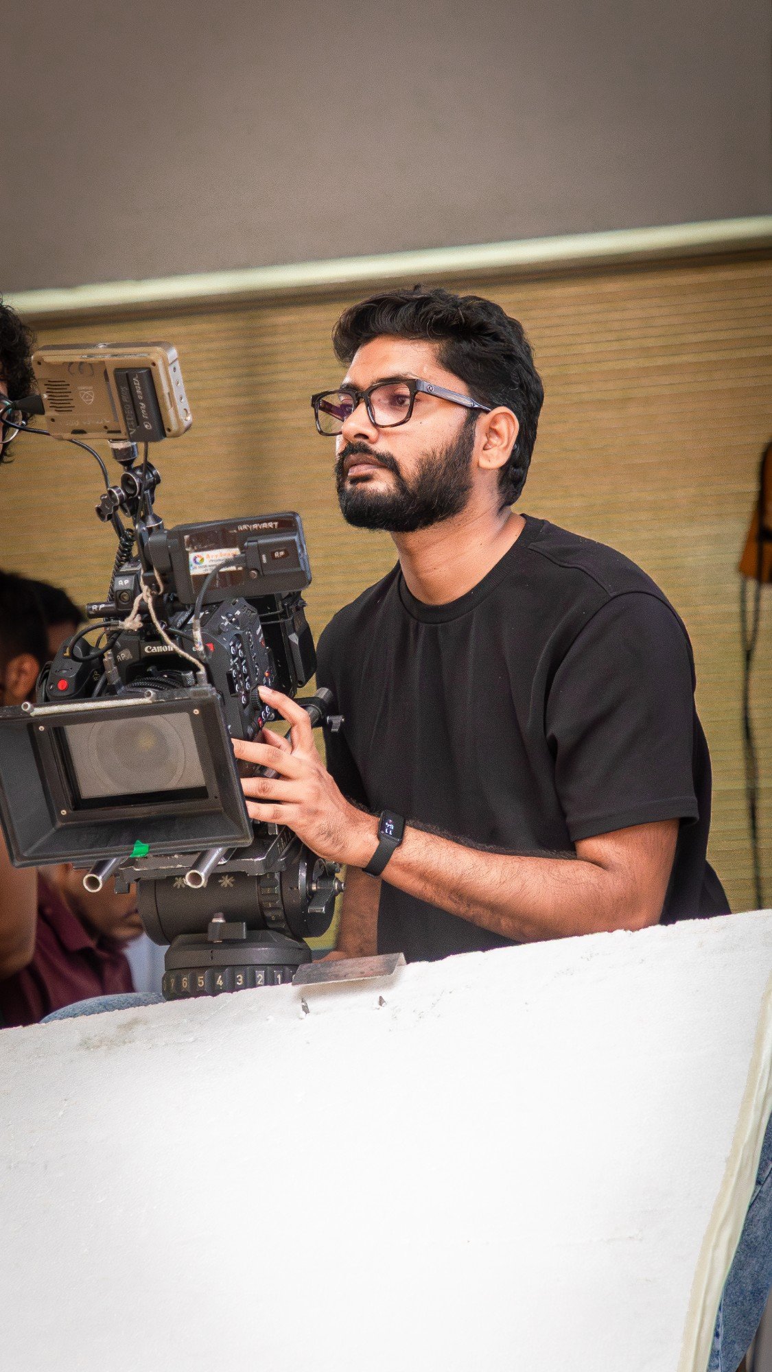 Akshay Kathe on set, behind a Canon cinema camera